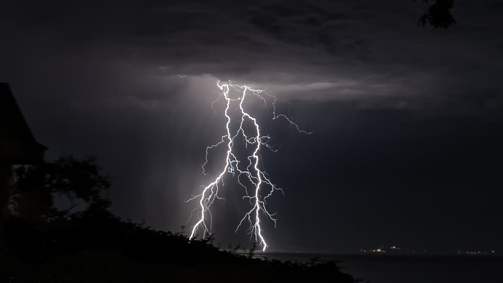 Lightning storm striking over a neighborhood at night