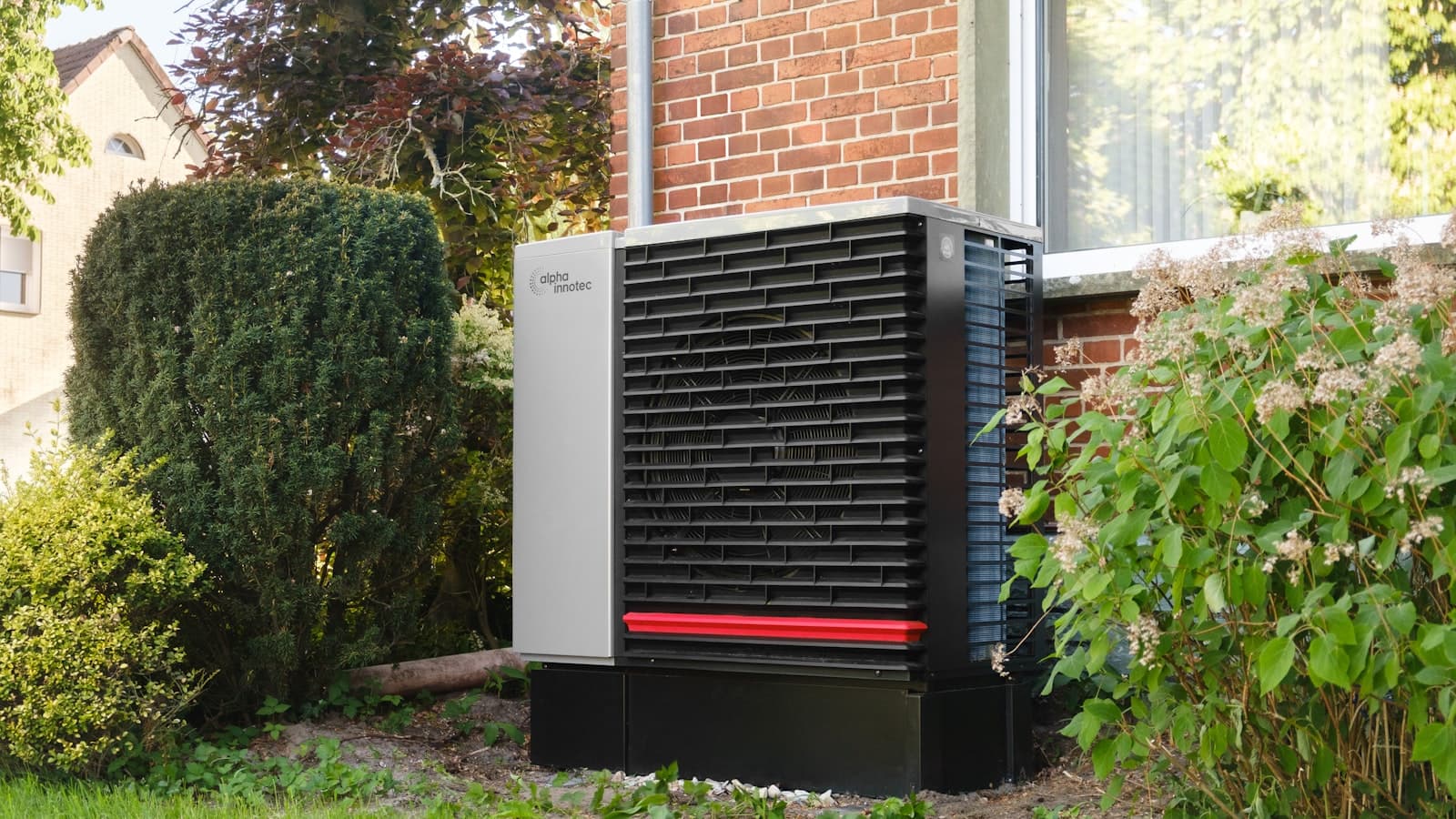 Outdoor home backup power unit installed on a pad beside a brick house